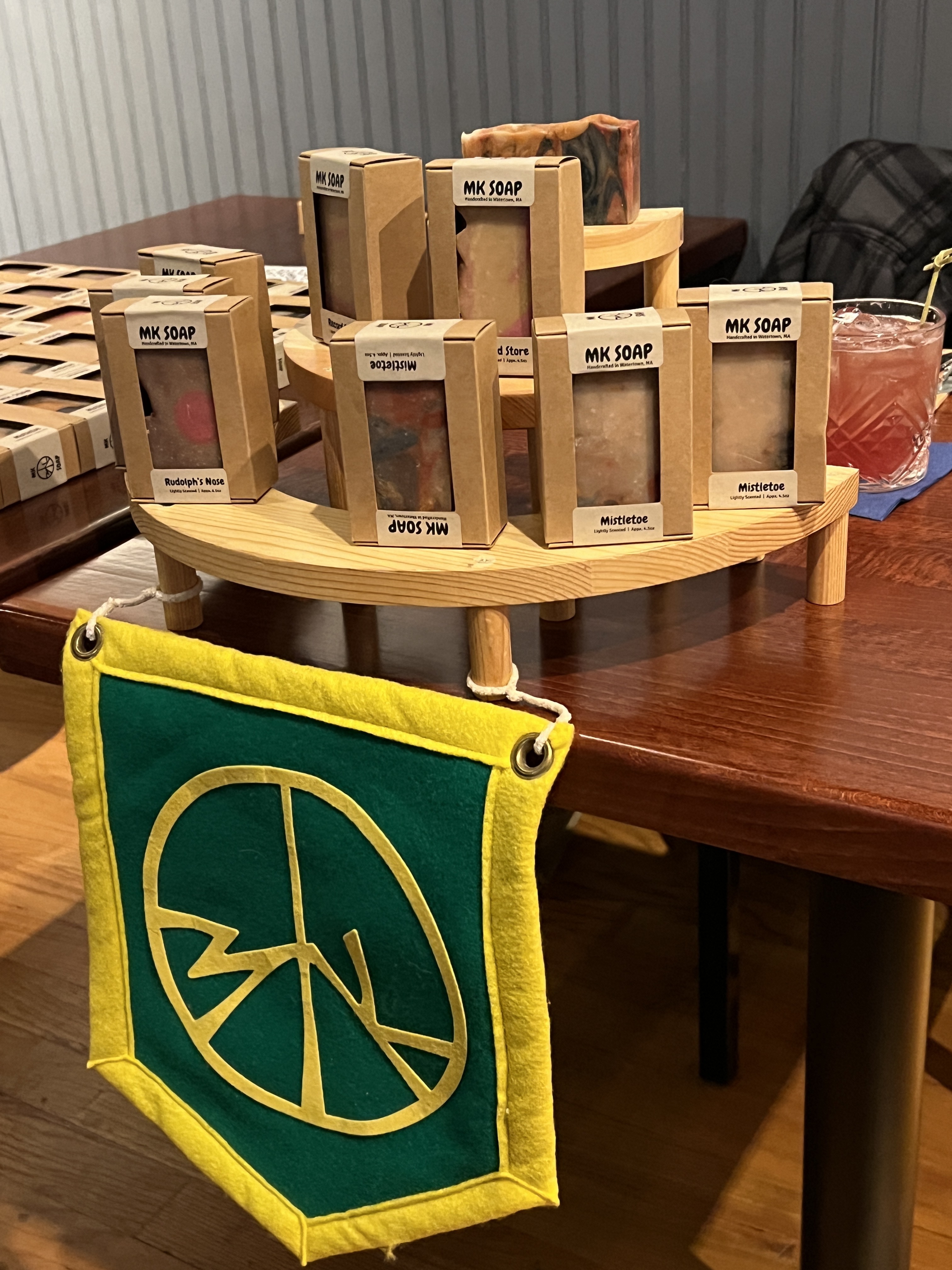 MK Soap felt pennant hanging beside a market display of boxed soaps