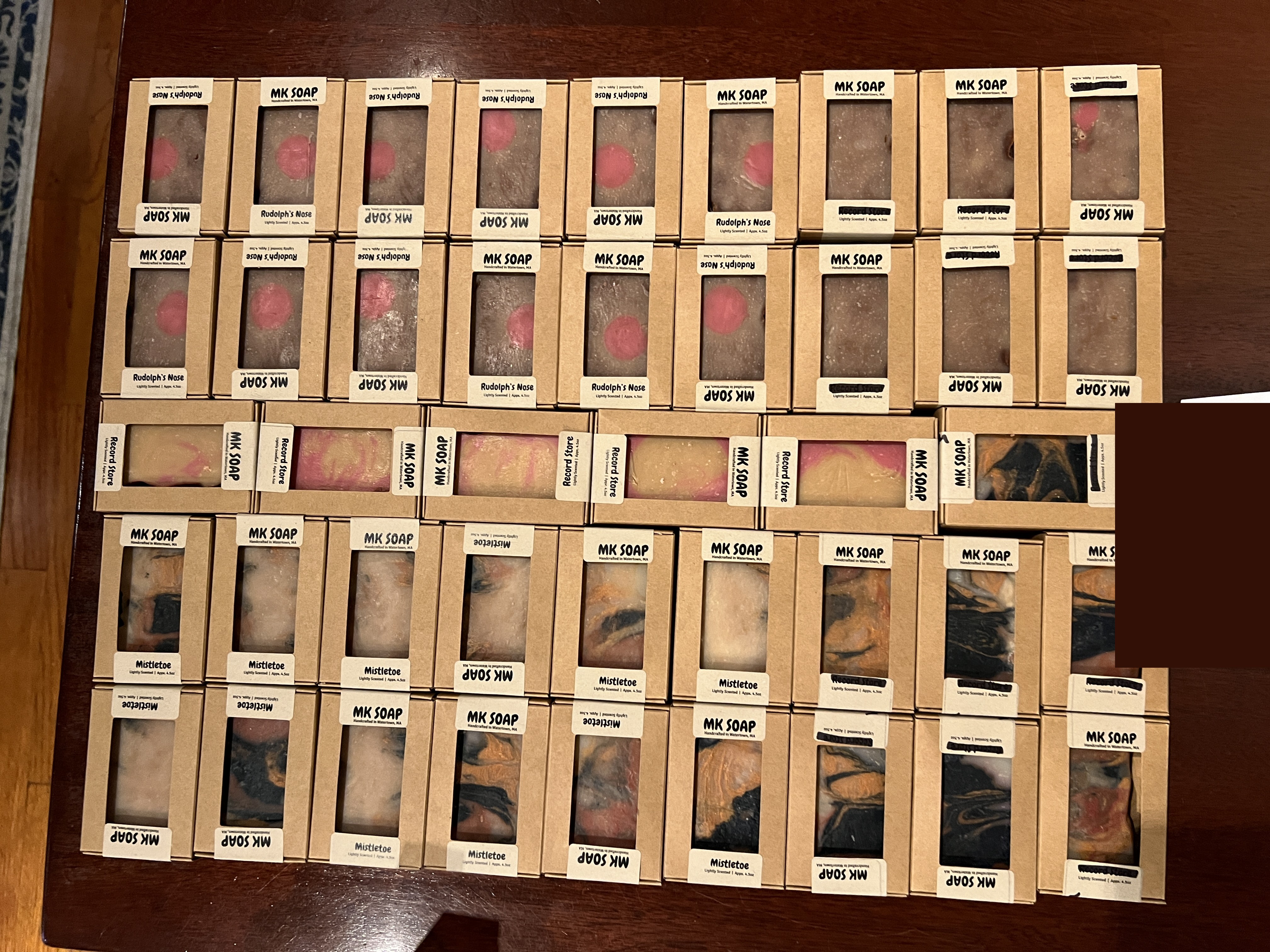 Flat lay of many boxed MK Soap bars in Rudolph's Nose, Record Store and Mistletoe scents