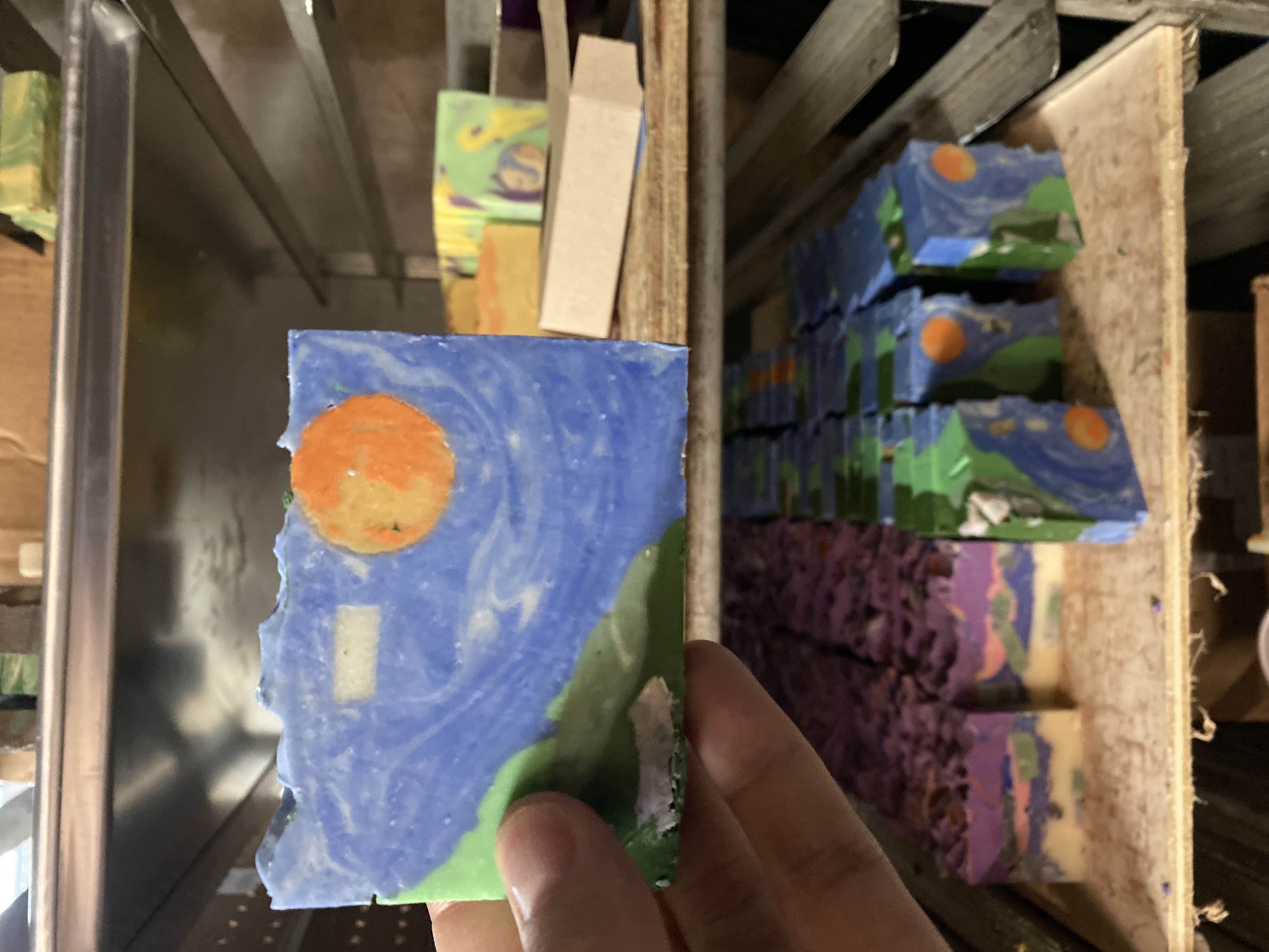 Soap bar with a Starry Night inspired design, held up in the workshop